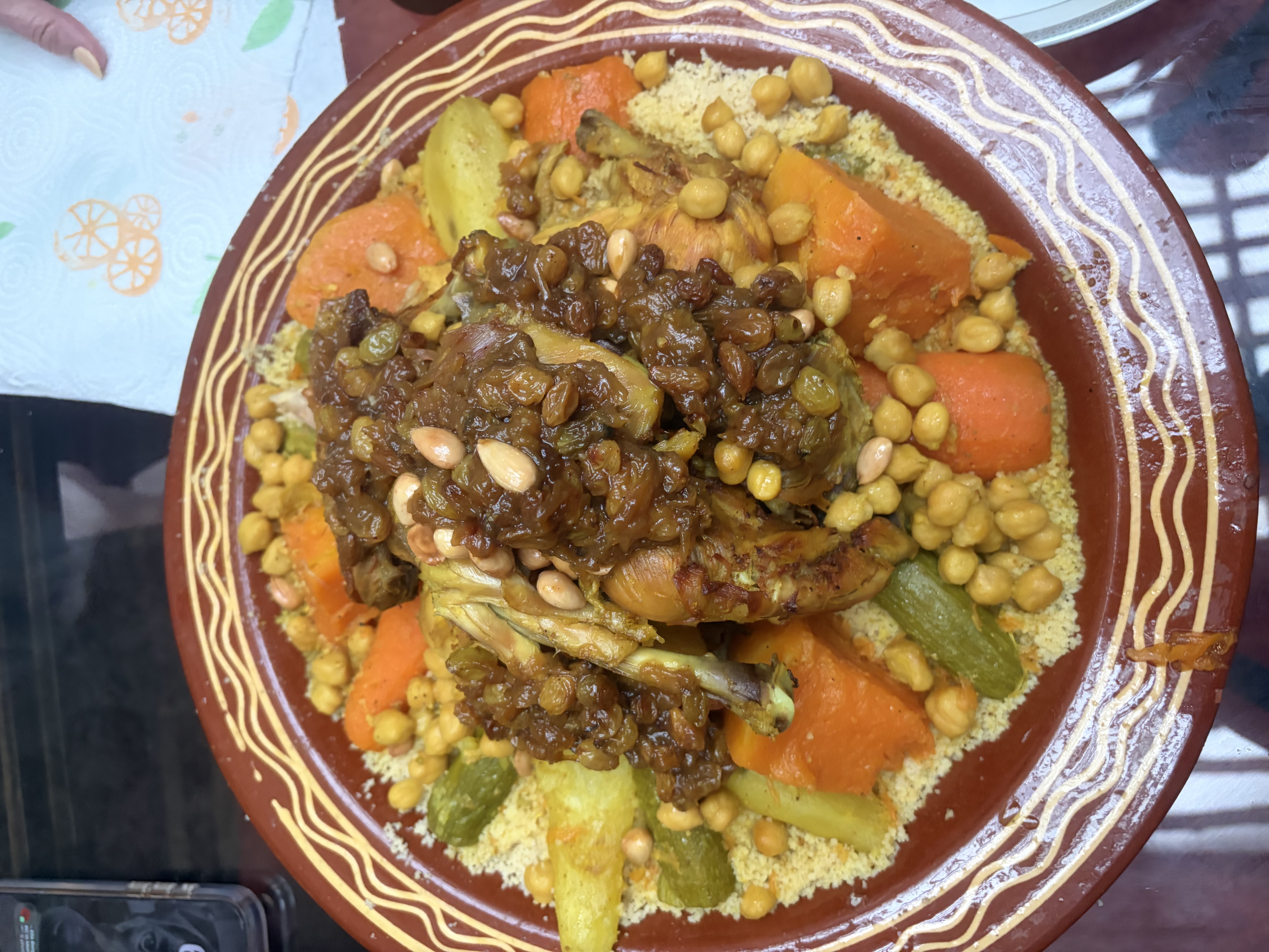 Traditional Friday couscous in Morocco, featuring chicken, vegetables, chickpeas, and sweet caramelized onions with raisins and almonds.