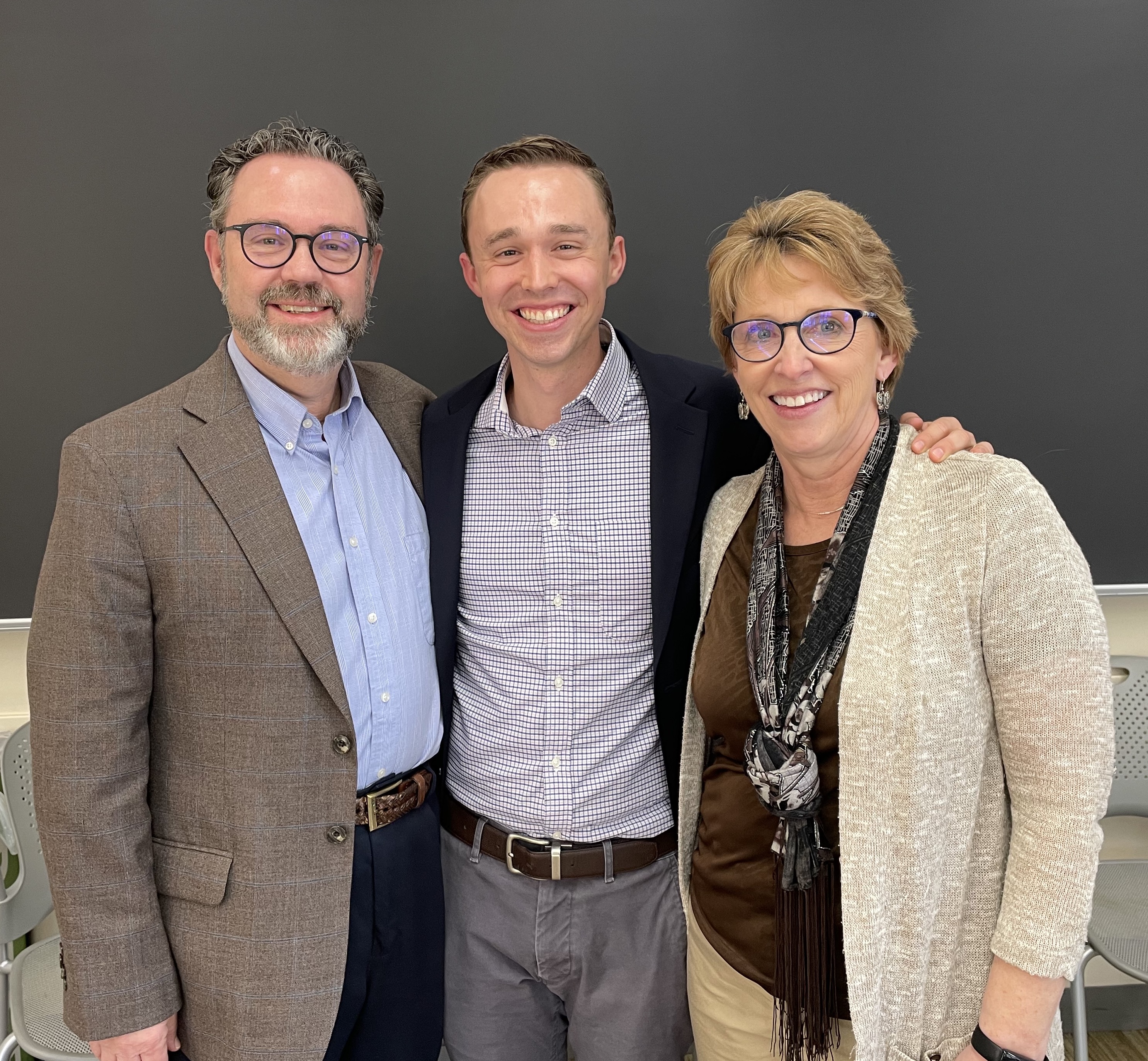Photograph of Connor S. Kenaston, a scholar of U.S. history, with his parents, Joe and Judi Kenaston, after his dissertation defense. Photograph by Maria Niechwiadowicz.